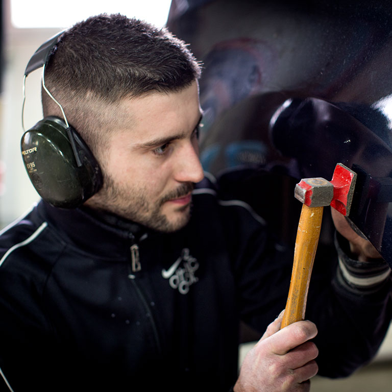 Jeune apprenti carrossier de l'École des Métiers rénove une carrosserie