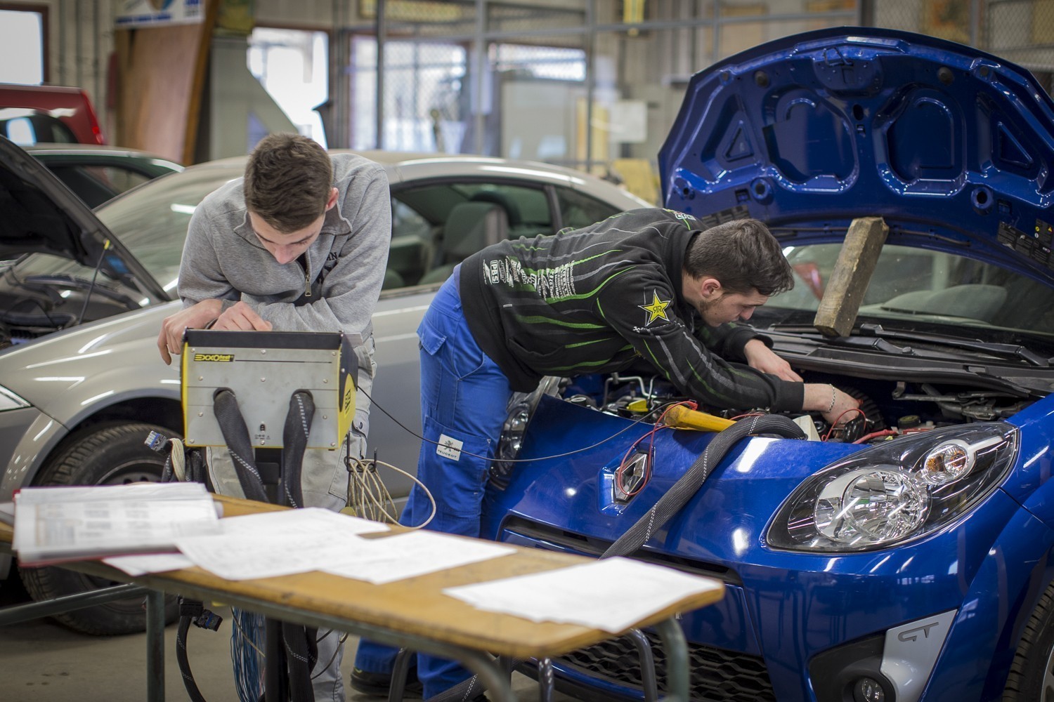 Apprentis en intervention de maintenance sur un véhicule dans l'atelier mécanique de l'Ecole des Métiers Dijon Métropole.