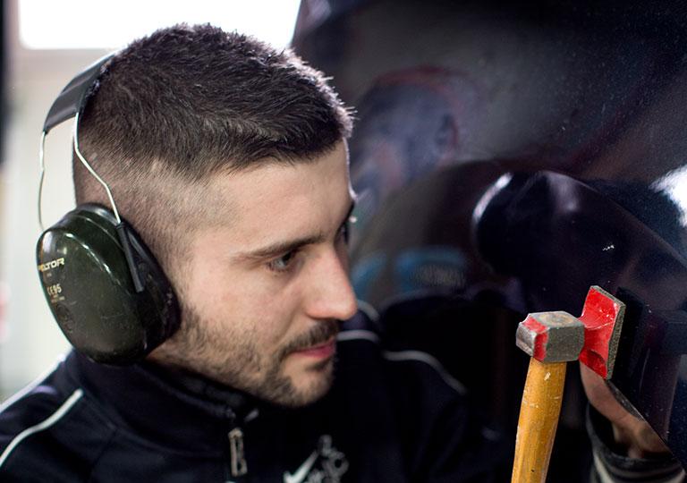 Jeune apprenti carrossier de l'École des Métiers rénove une carrosserie