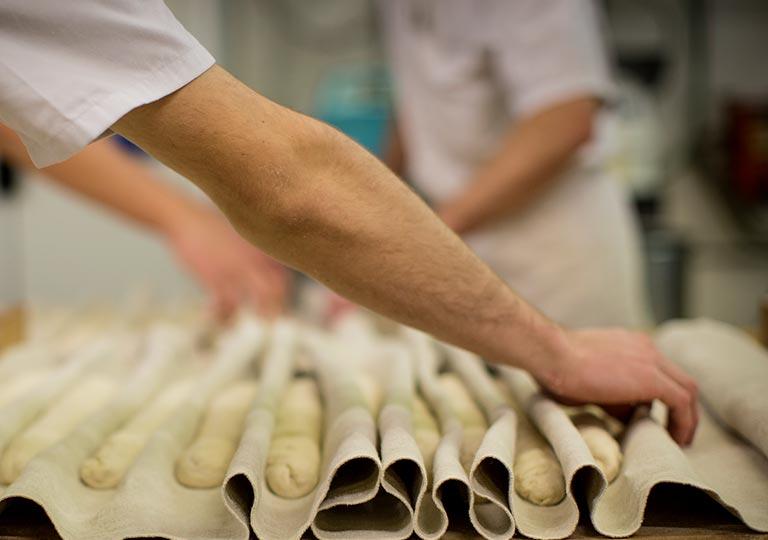 Apprenti boulanger dans le fournil de l'École des Métiers