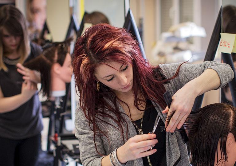 Apprentie coiffeuse suit un cours à l'École des Métiers