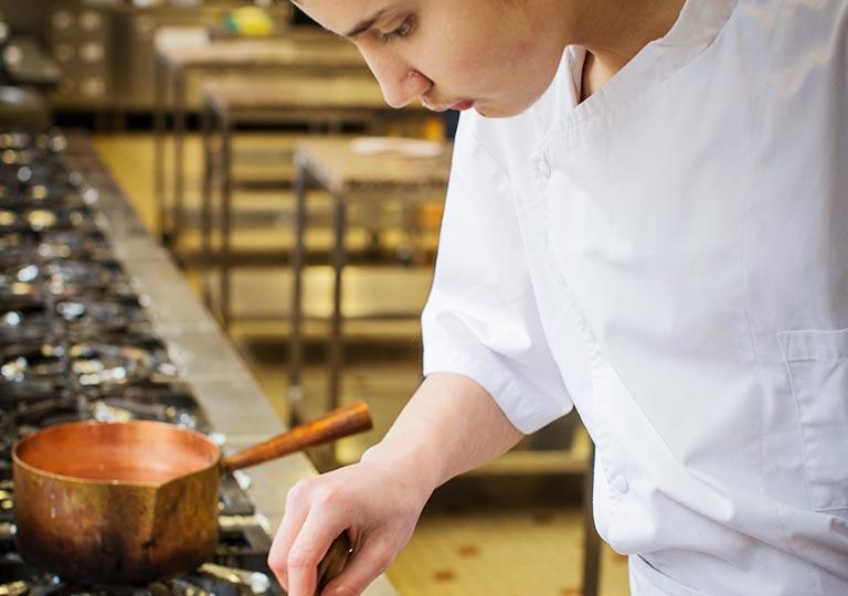 Un apprenti de l'Ecole des Métiers prépare un caramel dans le laboratoire de pâtisserie